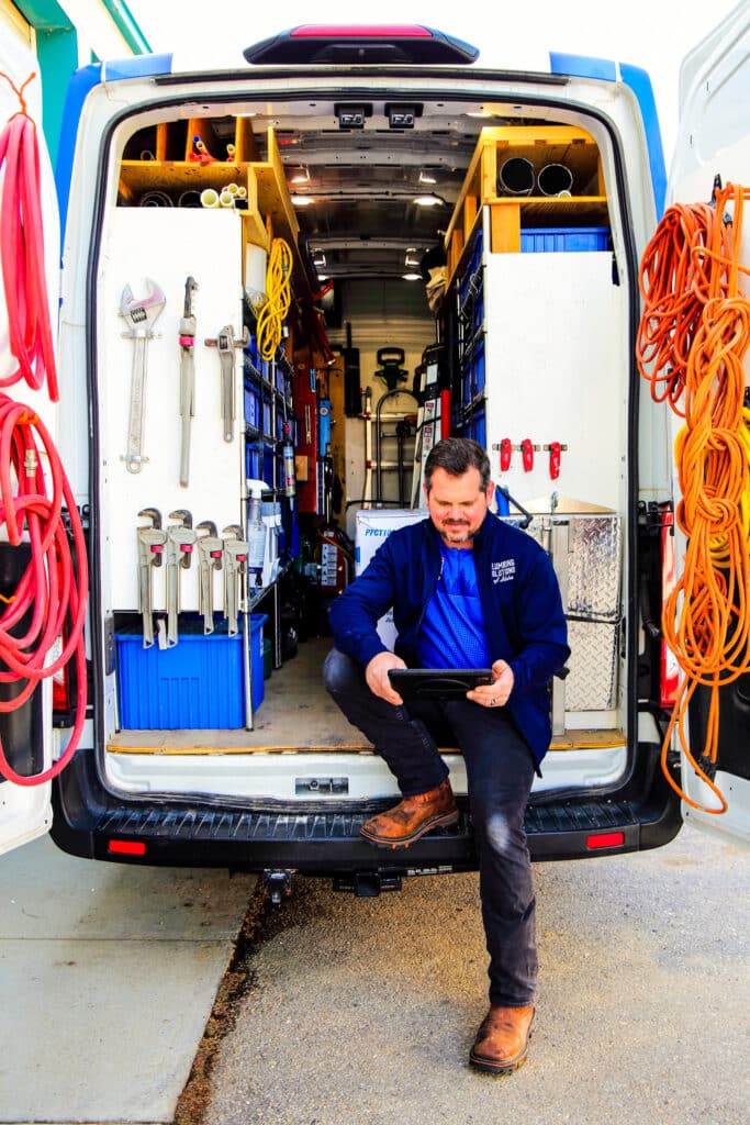 Plumbing Solutions of Idaho plumbers sitting in back of service van