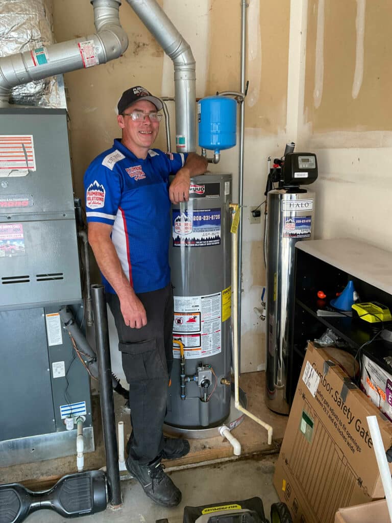 Employee standing next to finished water heater installed in Boise, ID