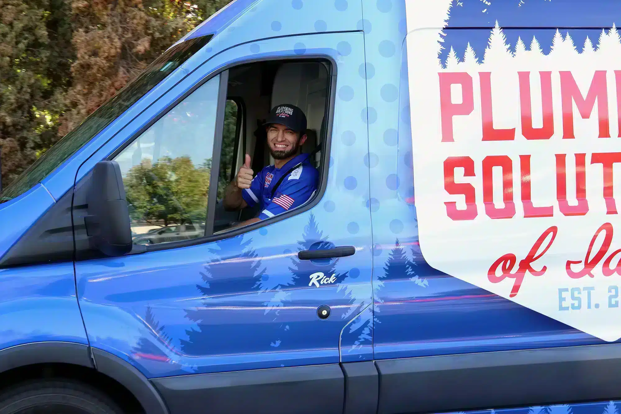 Plumbing Solutions of Idaho employee in work van giving a thumbs up