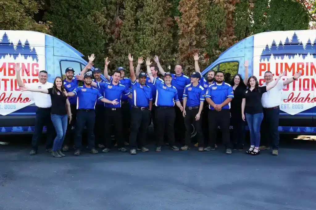 Plumbing Solutions of Idaho team funny photo in front of work vans