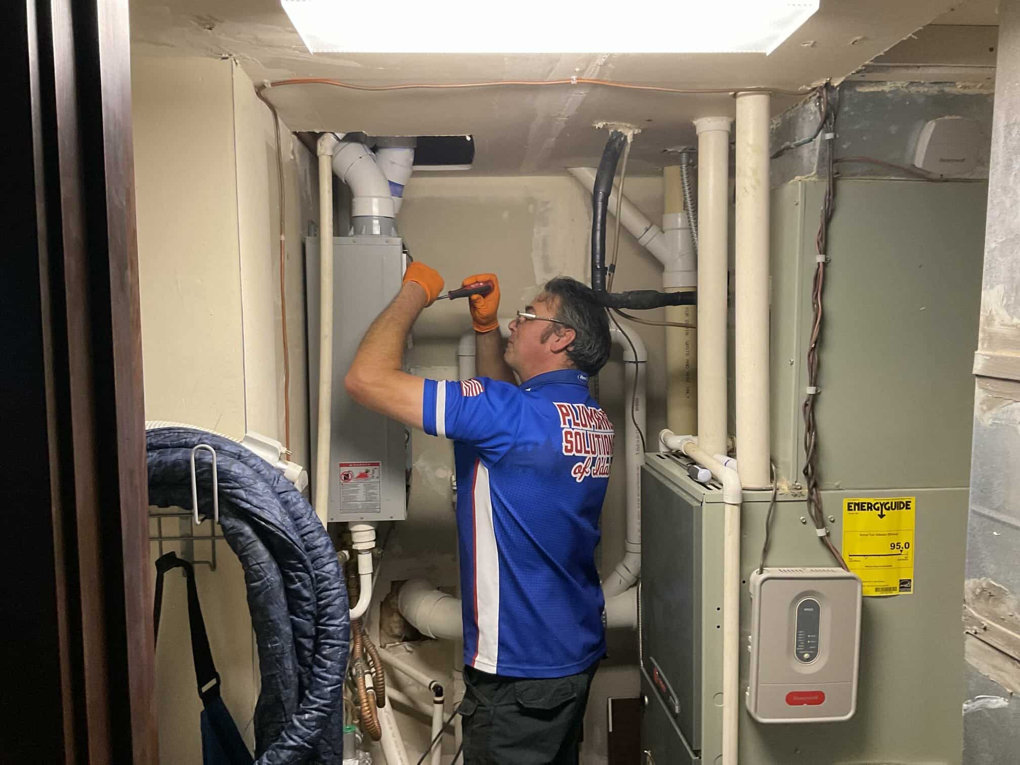 Plumbing Solutions of Idaho employee working in basement on pipping in Boise, ID